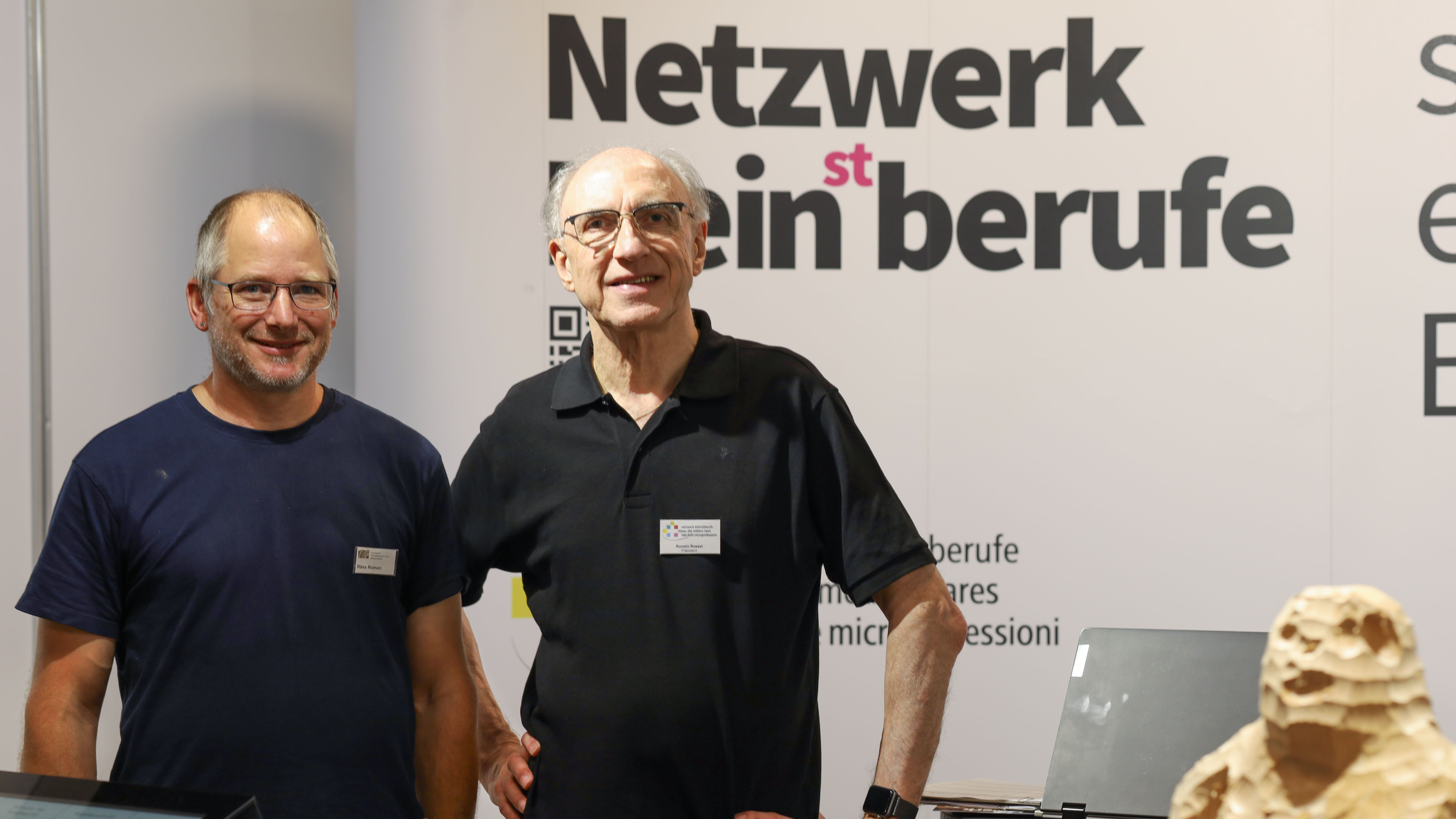 Romain Rosset und Roman Räss stehen am Stand vom Netzwerk Kleinstberufe an der Aargauischen Berufsschau. | © ask! – Beratungsdienste für Ausbildung und Beruf