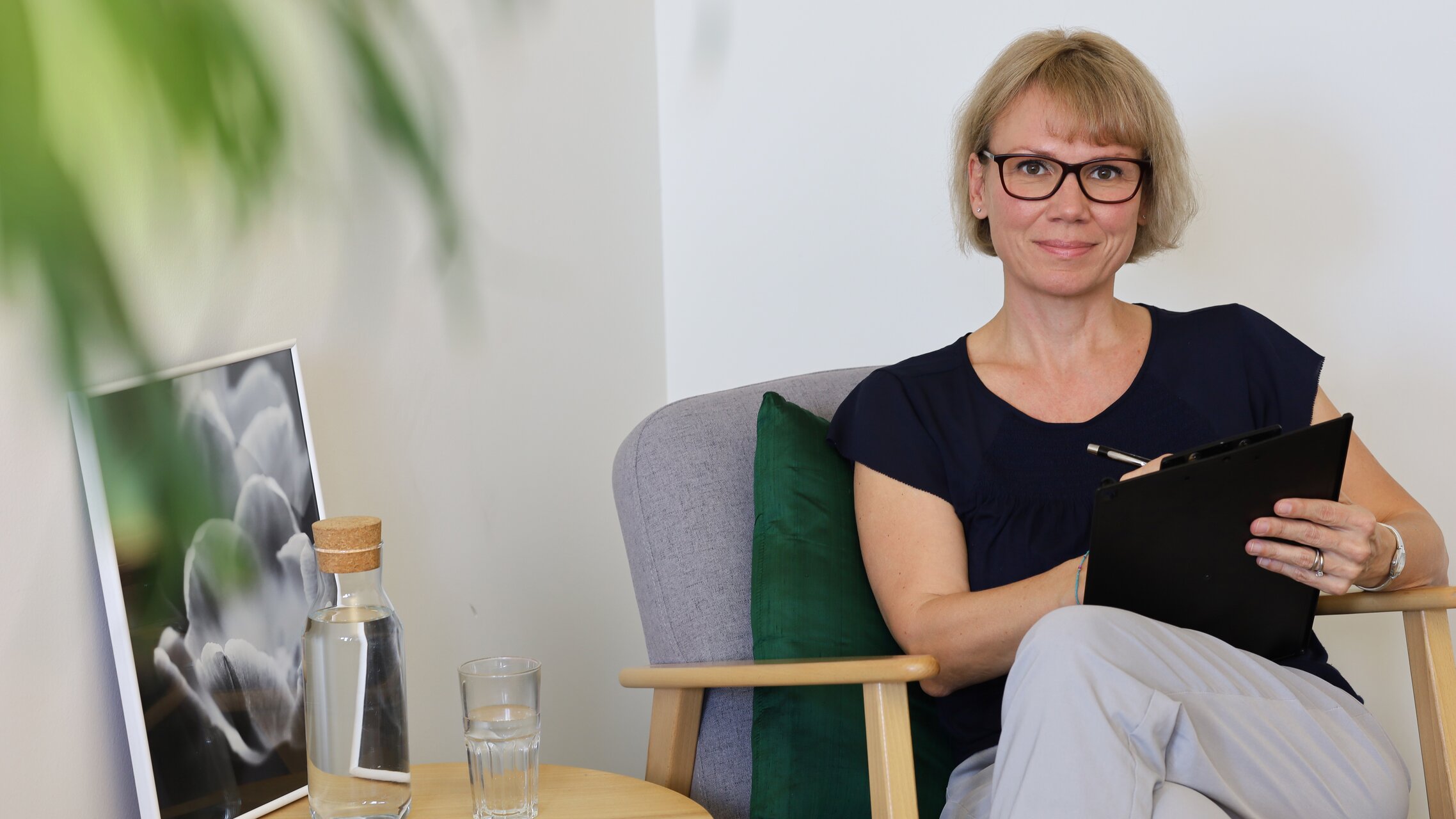 Sandra Senti sitzt auf einer Couch mit einem Klemmbrett in der Hand | © ask!