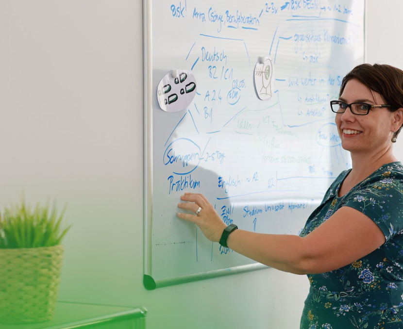 Anna Csönge zeigt einem Kunden etwas am Whiteboard | © ask! – Beratungsdienste für Ausbildung und Beruf