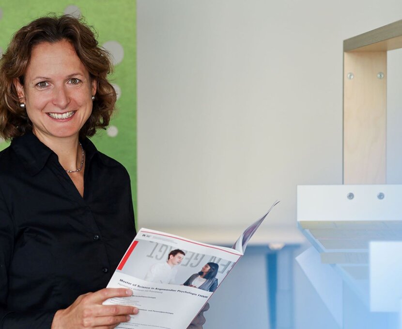 Andrea Gisin-Finckh hält eine Broschüre in der Hand und lacht in die Kamera | © ask! – Beratungsdienste für Ausbildung und Beruf