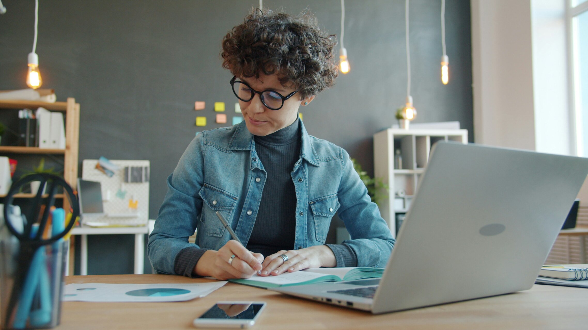 Frau vor Laptop, rechnet etwas aus, studiert Diagramm | © Unsplash, Vitaly Gariev