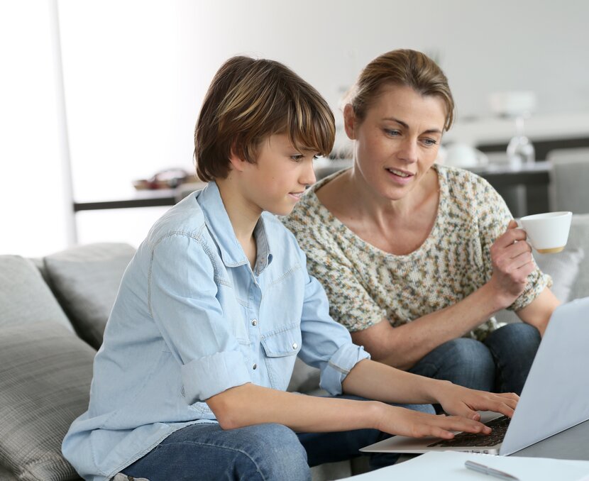 Mutter und Sohn schauen sich gemeinsam Infos auf dem Laptop an | © Shutterstock