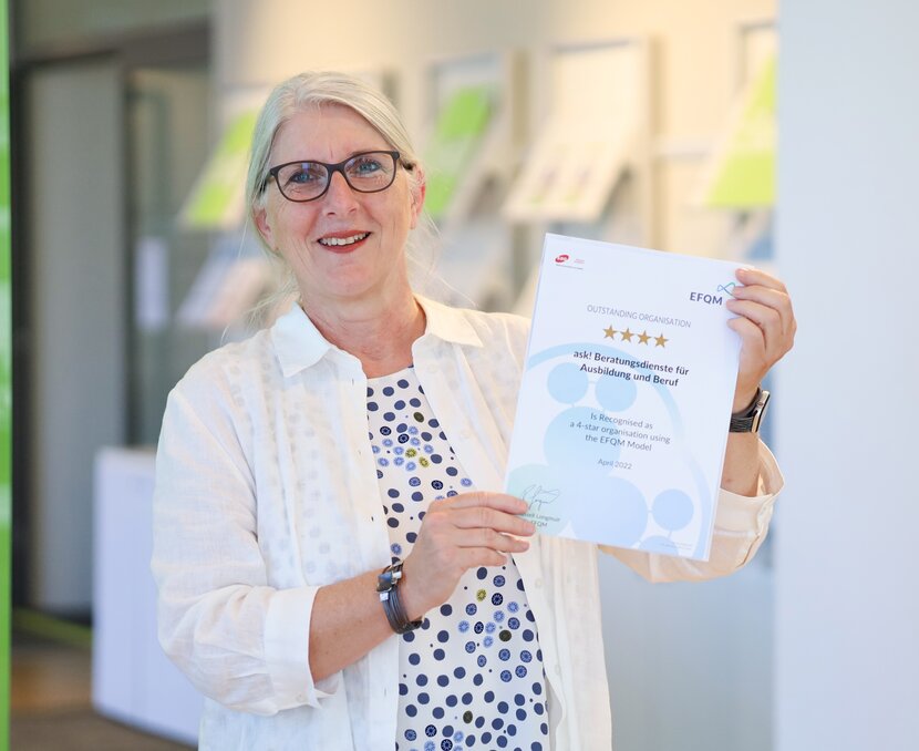 Sonja Brönnimann hält das EFQM-Zertifikat in der Hand. | © ask! - Beratungsdienste für Ausbildung und Beruf