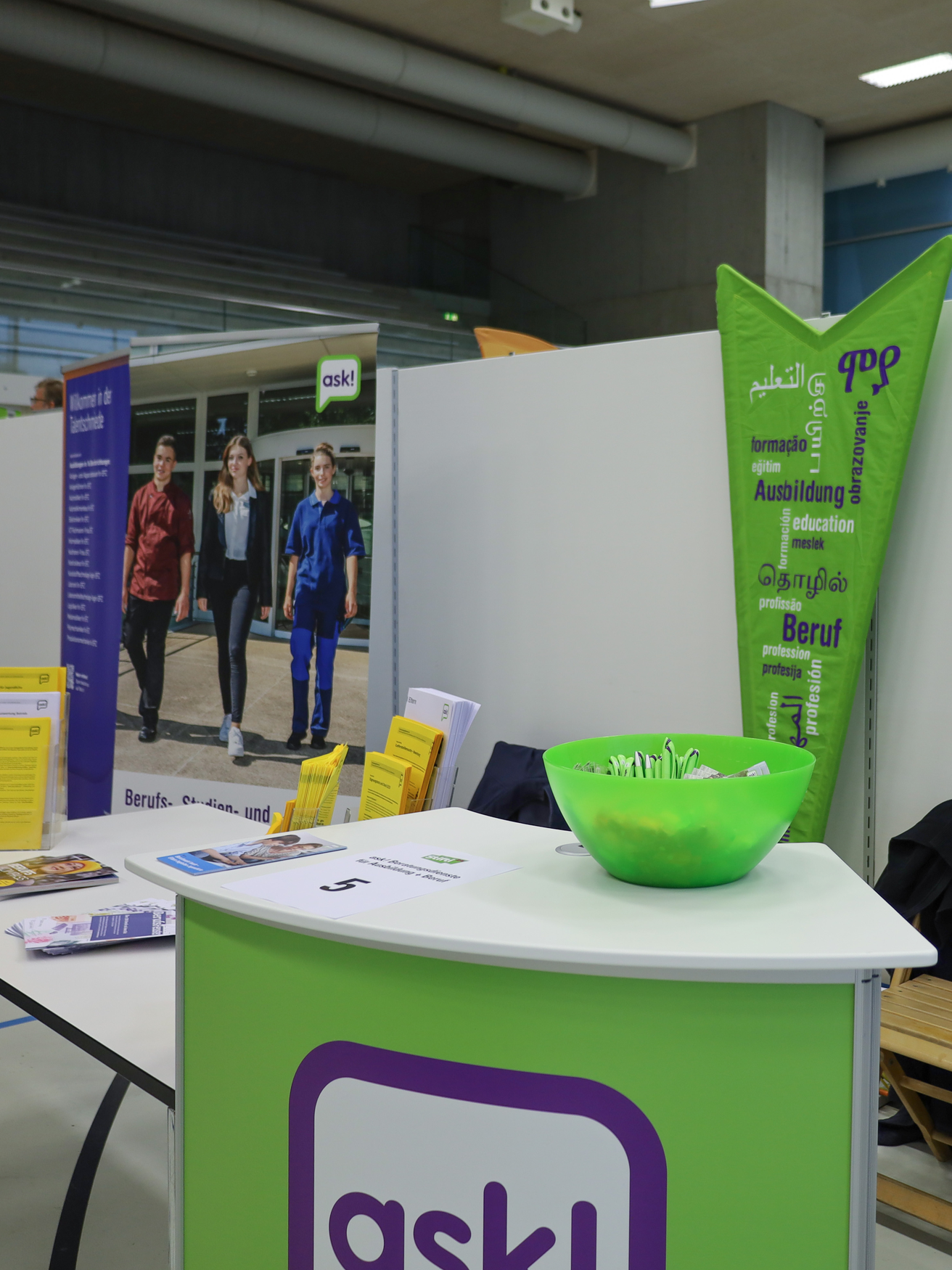 Stand von ask! an der Stifti'24 mit Tisch, Flyern, Roll Ups etc. | © ask! – Beratungsdienste für Ausbildung und Beruf