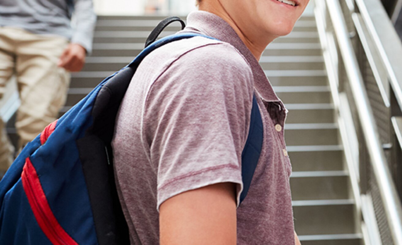 Schüler mit Rucksack steht vor Treppe | © Shutterstock